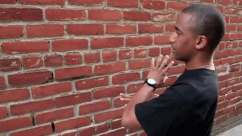 Man In Front Of Red Brick Wall GIF