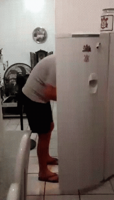 Man In Front Of Refrigerator With Strawberry Sticker GIF