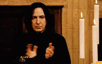 Man In Front Of Row Of Lit Candles GIF