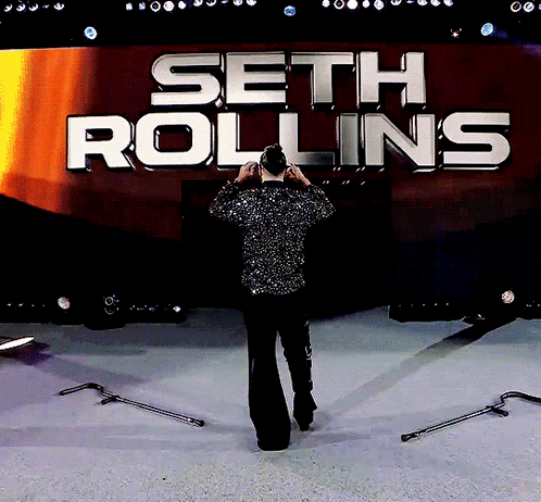 Man In Front Of Seth Rollins Sign GIF