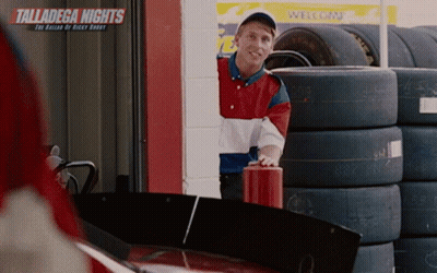 Man In Front Of Talladega Nights Sign And Tires GIF