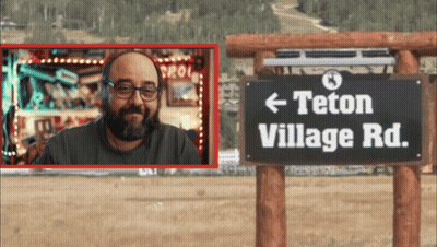Man In Front Of Teton Village Road Sign GIF