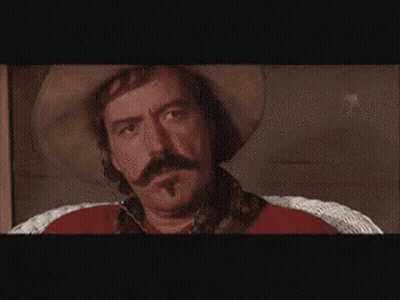 Man In Front Of Wall Of Pictures GIF