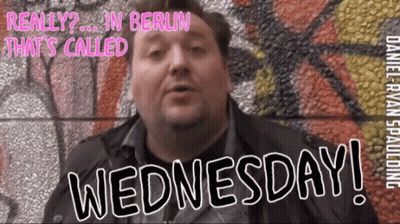 Man In Front Of Wall Saying Wednesday GIF