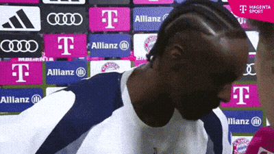 Man In Front Of Wall With T-Mobile Allianz Audi Logos GIF