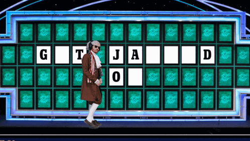 Man In Front Of Wheel Of Fortune Board With G T J A O D GIF
