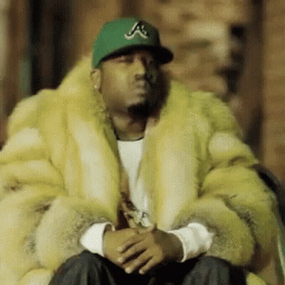 Man In Fur Coat And Green Hat With Letter A GIF