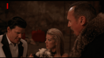 Man In Fur Coat Next To Woman And Man In Suit With Devil And Red Letters GIF