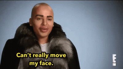 Man In Fur Coat Saying Can't Really Move My Face GIF