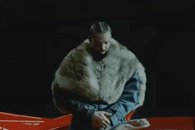 Man In Fur Coat Sitting On Red Car GIF