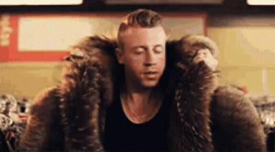Man In Fur Coat Sitting With Eyes Closed GIF