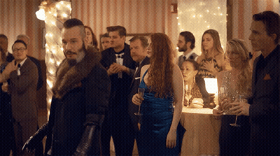 Man In Fur Coat Standing In Crowd GIF