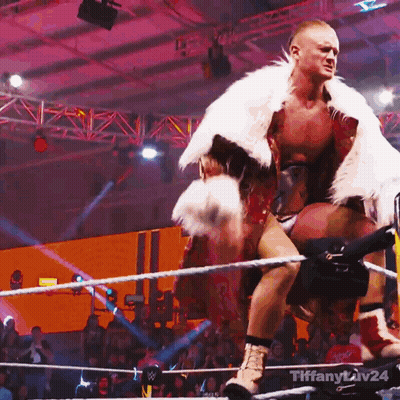 Man In Fur Coat Standing In Wrestling Ring With Tiffany Liv24 GIF