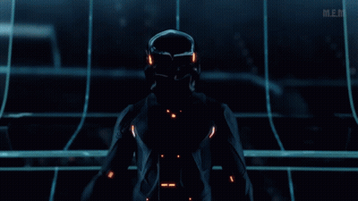 Man In Futuristic Suit Standing In Dark Room With Mem GIF