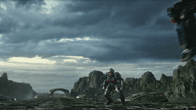 Man In Futuristic Suit Walking Across Bridge With Mountains GIF