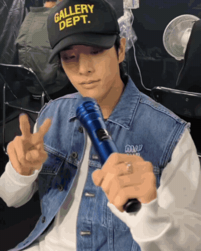 Man In Gallery Dept Hat Holding Microphone GIF