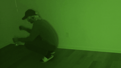 Man In Gas Mask Kneeling In Green Room GIF