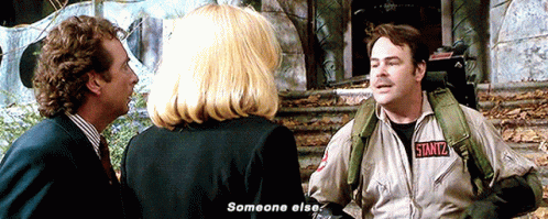 Man In Ghostbusters Jacket Talking To Woman And Man In Suit GIF