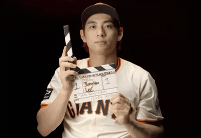 Man In Giants Jersey Holding Clapper Board GIF