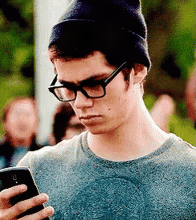 Man In Glasses And Beanie Looking At Phone GIF