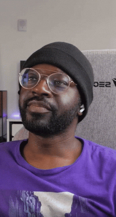 Man In Glasses And Black Beanie Sitting In Front Of Oe2 Wall GIF