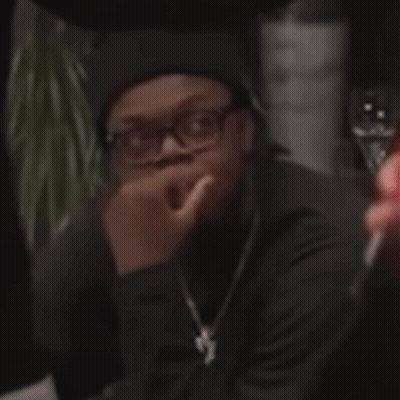 Man In Glasses And Black Hat Sitting With Hand On Nose GIF