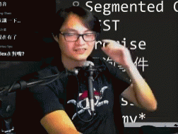Man In Glasses And Black Shirt In Front Of Microphone With Segmented On Blackboard GIF