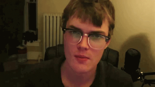 Man In Glasses And Black Shirt Looking At Camera GIF