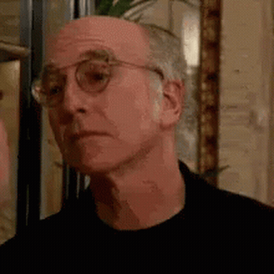 Man In Glasses And Black Shirt Looking At Camera GIF