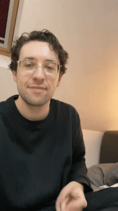 Man In Glasses And Black Shirt On Bed GIF