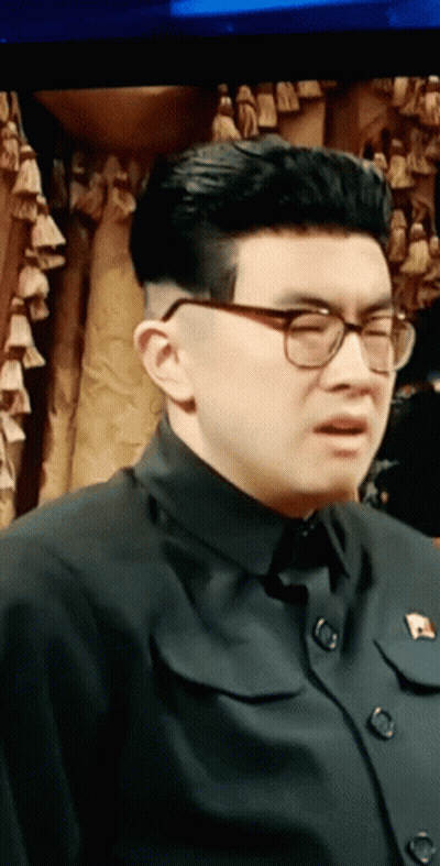 Man In Glasses And Black Shirt With Pin GIF