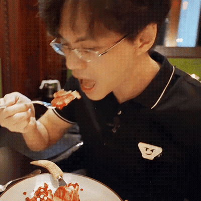 Man In Glasses And Black Smiley Shirt Eating Food GIF