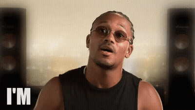 Man In Glasses And Black Tank Top Says I'm In Front Of Speakers GIF