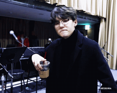 Man In Glasses And Black Turtleneck Holding Coffee With Straw GIF