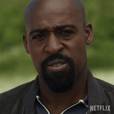 Man In Glasses And Blue Jacket Looking At Camera GIF
