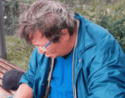 Man In Glasses And Blue Jacket On Park Bench GIF