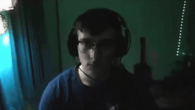 Man In Glasses And Blue Shirt Looking At Camera GIF