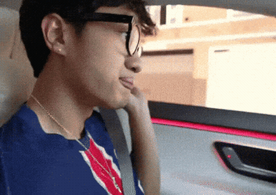 Man In Glasses And Blue Shirt Looking Out Car Window GIF