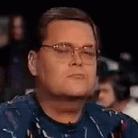 Man In Glasses And Blue Shirt Sitting In Crowd GIF
