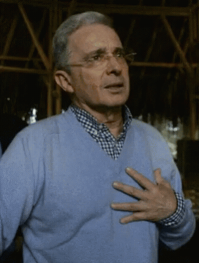 Man In Glasses And Blue Sweater Holding Chest GIF