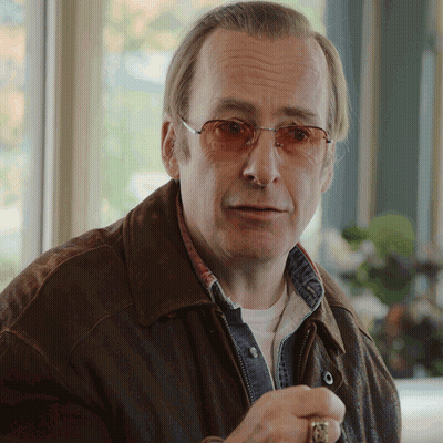 Man In Glasses And Brown Jacket Looking At Camera GIF