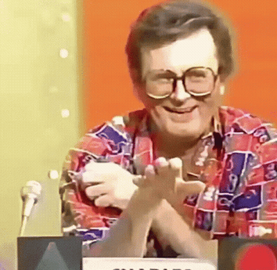 Man In Glasses And Colorful Shirt At Microphone GIF