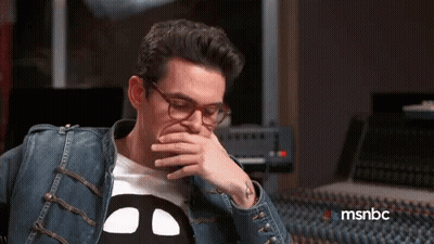 Man In Glasses And Denim Jacket Covering Mouth GIF