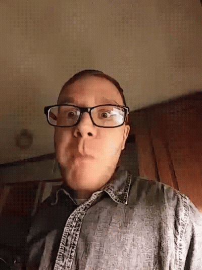 Man In Glasses And Denim Shirt Making A Face GIF