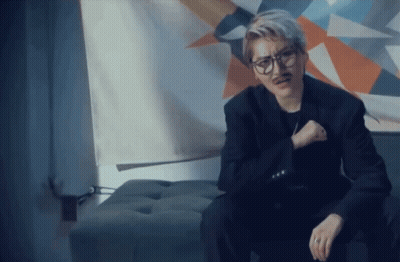 Man In Glasses And Fake Mustache Sitting On Ottoman GIF