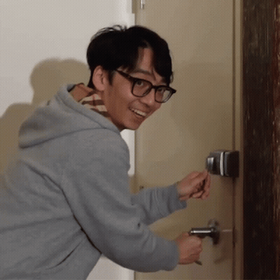Man in Glasses and Grey Hoodie Opening Door With Key