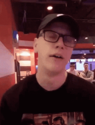 Man In Glasses And Hat Looks At Camera GIF