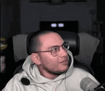 Man In Glasses And Hoodie Sitting At Microphone GIF