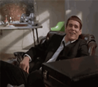 Man In Glasses And Name Tag In Front Of White Building GIF