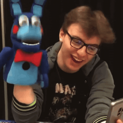 Man In Glasses And NBA Shirt Smiling With Stuffed Animal GIF